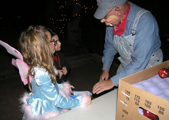 Jesse Tomory hands out apples at Rubel Castles' Halloween Open House  pharmtrickrtreat_061031.005